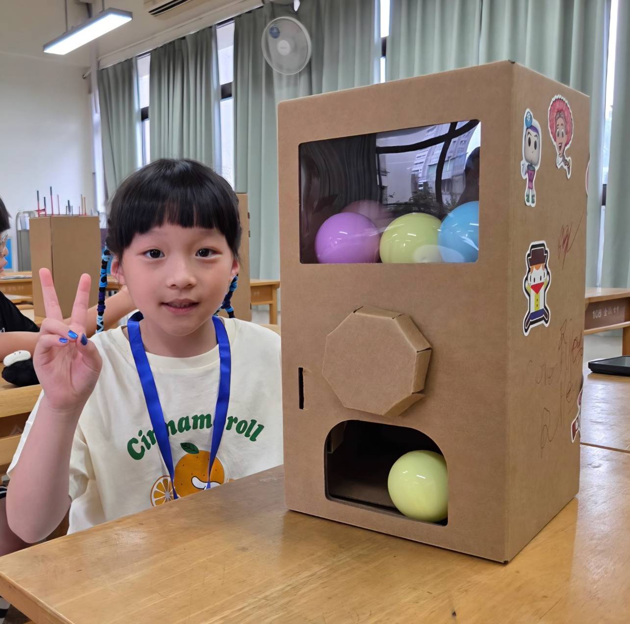 孩子展示完成的驚喜扭蛋機教材