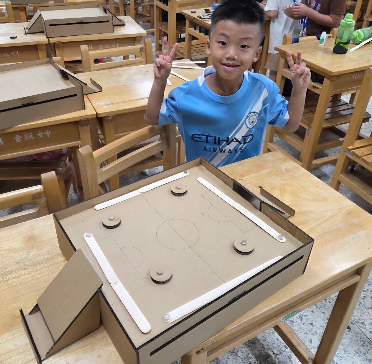 孩子展示完成的對戰冰球台教材